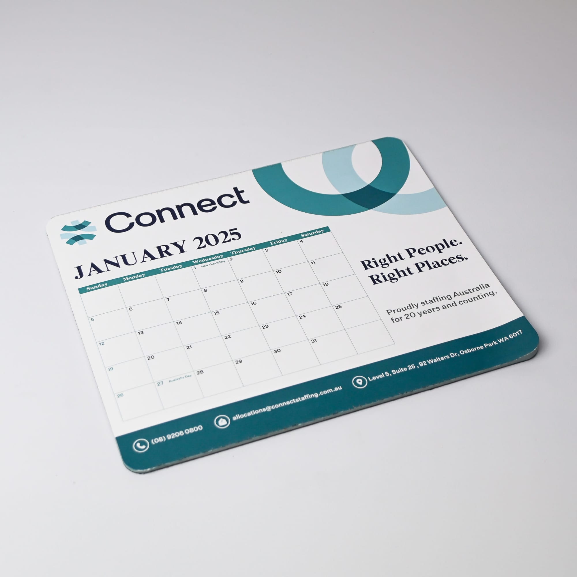 A mouse mat featuring a calendar for January 2025, in blue and green tones, with a logo and Australian-made badge.