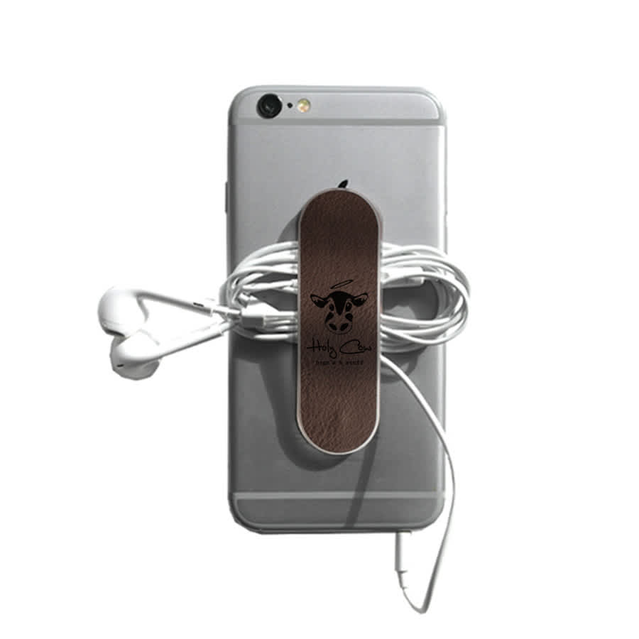 A smartphone with a brown leather strap holding white earphones. The phone has a logo on it.