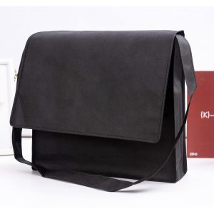 A black non-woven flap satchel with a shoulder strap and branding logo displayed.