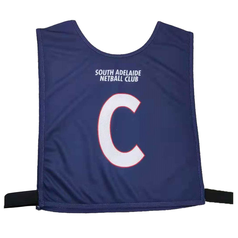 A navy blue netball bib featuring a large white letter 
