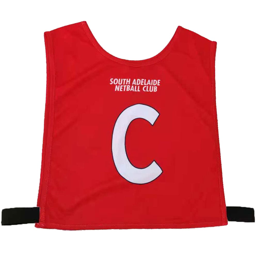 Red pull-over netball bib featuring a white letter 