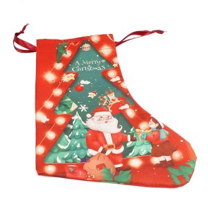 A red Christmas stocking featuring Santa surrounded by festive decorations and a tree design. Includes a decorative drawstring.