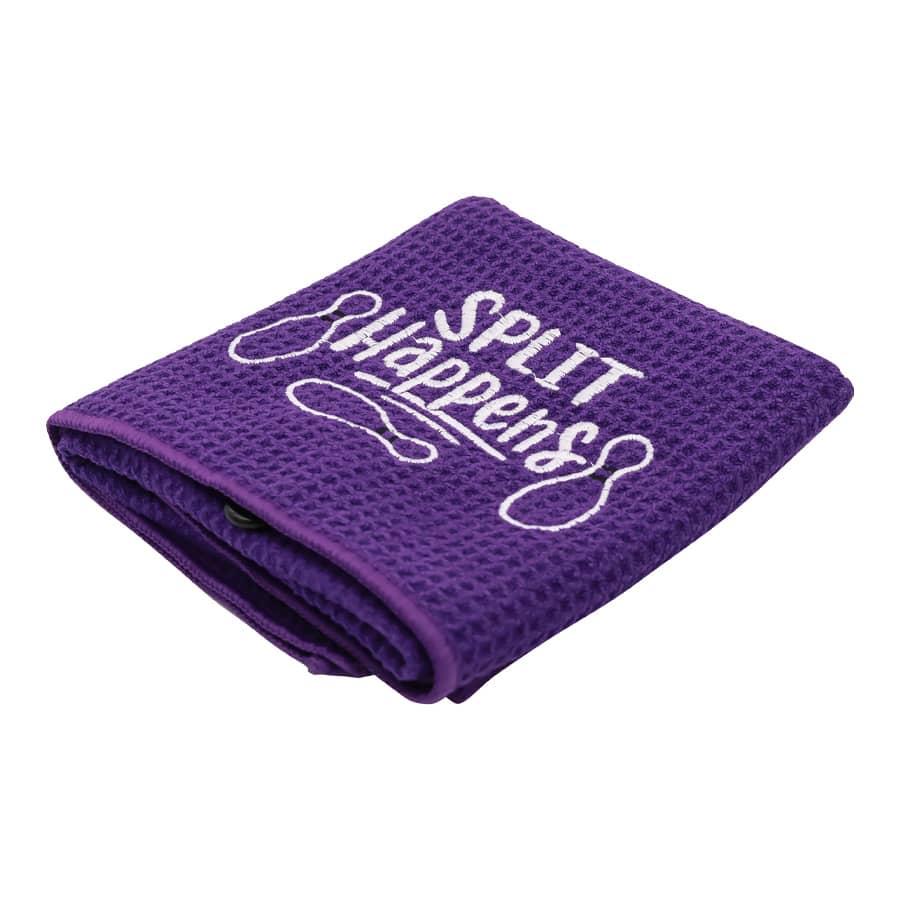 A purple golf towel with a textured surface and a logo. It features the phrase 
