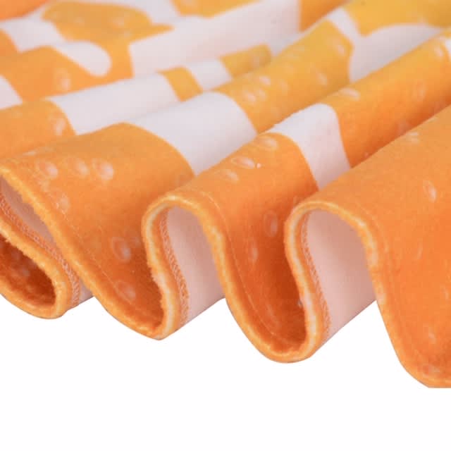 An orange and white patterned face washer with a soft, textured edge, featuring a wavy fold. It has a branding logo.