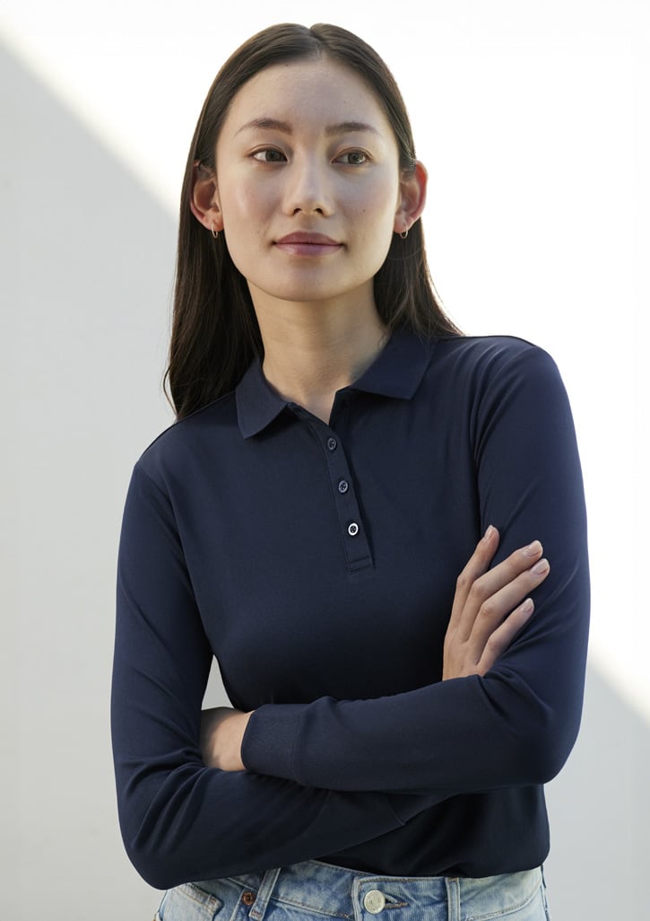 A long sleeve polo shirt in navy blue, featuring a collar and button placket, worn by a model with long hair.