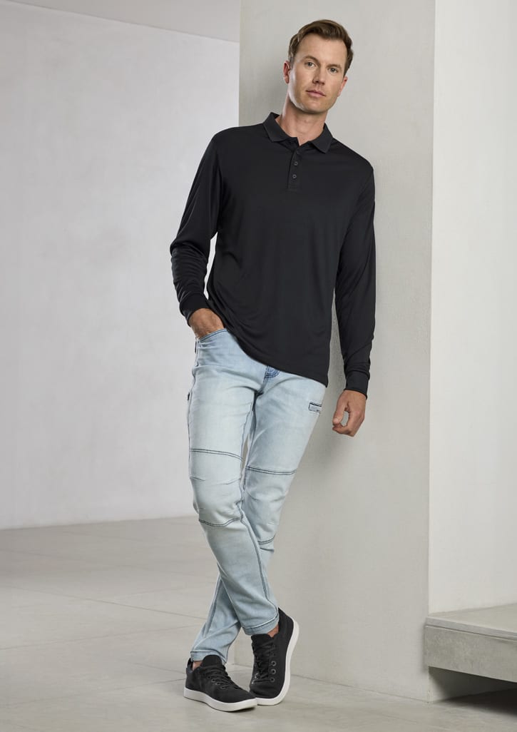 A black long sleeve polo shirt worn by a man, paired with light blue jeans and dark shoes, standing against a wall.