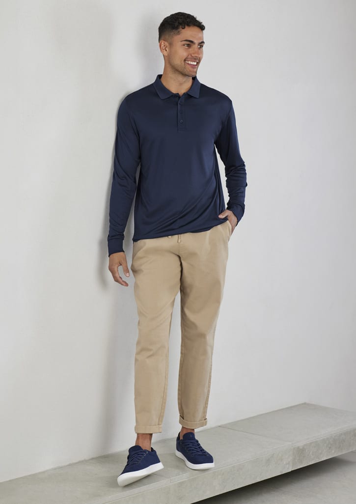 A long sleeve navy polo shirt worn with beige trousers and navy sneakers, featuring a logo.