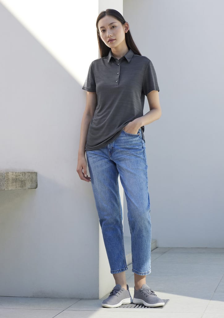 A grey short sleeve polo shirt with a subtle pattern, paired with light blue jeans and grey sneakers.