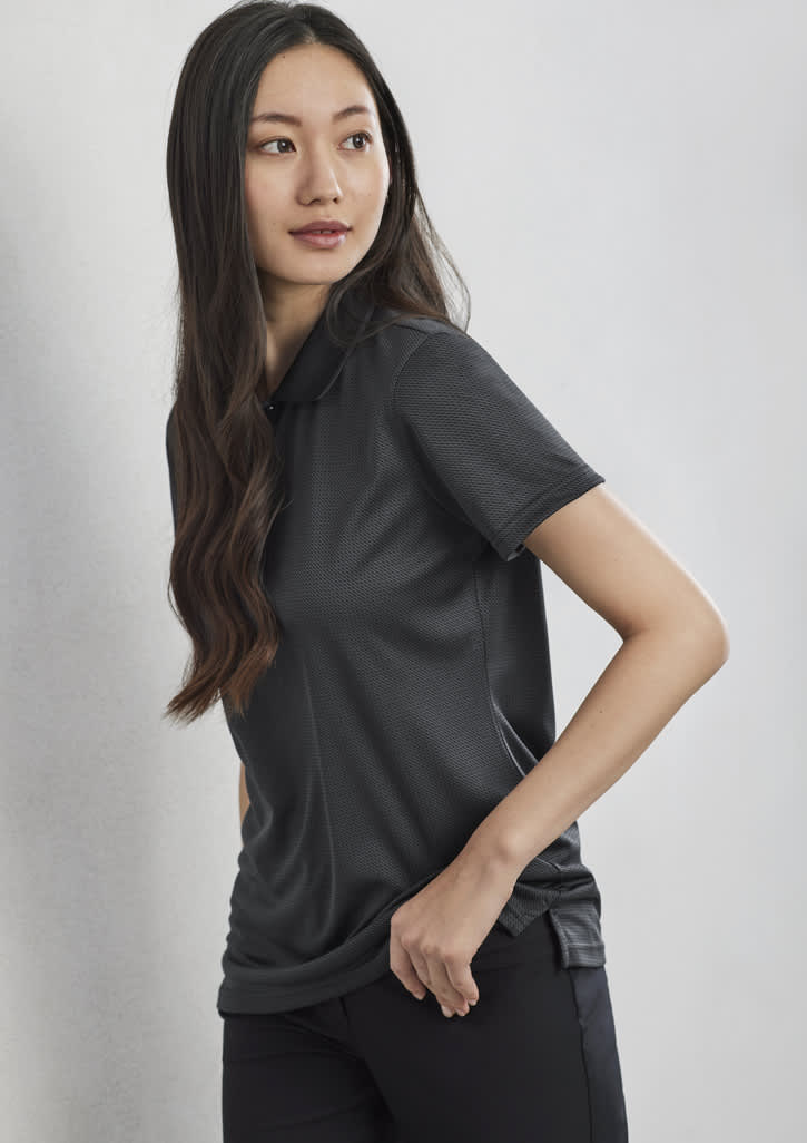 A woman wearing a black short sleeve polo shirt, featuring a collar and a logo on the side.