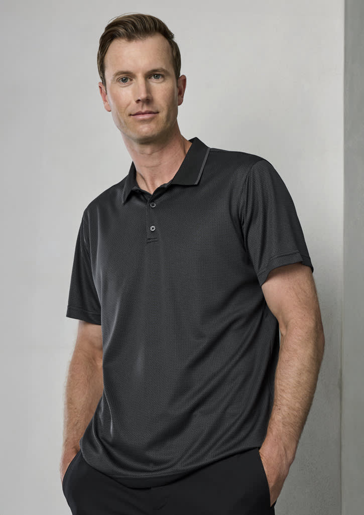 A man wearing a black short sleeve polo shirt with a collar. The shirt features a subtle texture and has a logo.