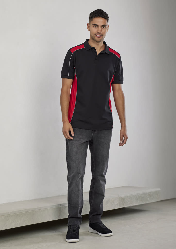 A unisex polo shirt in black with red side panels, featuring short sleeves and a logo. Styled with grey jeans.