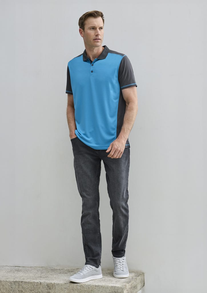 A men's short sleeve polo in blue and grey, featuring a logo, paired with dark jeans and sneakers.