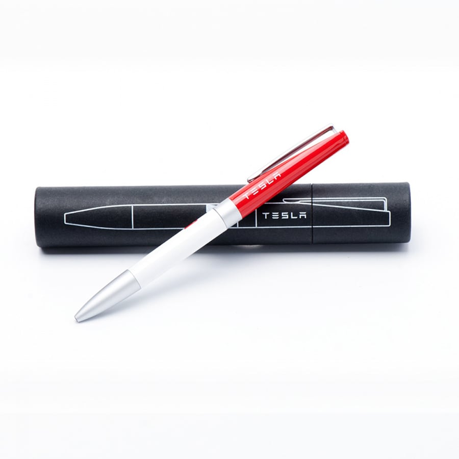 A metal ball pen in red and white, placed on a black casing with a logo.