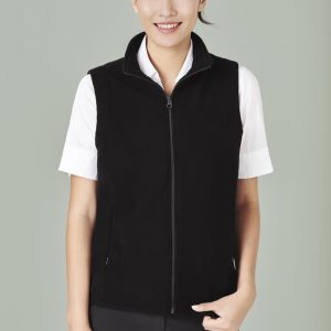 A black micro fleece vest with a zip, worn over a white shirt, featuring side pockets and a neckline zip.