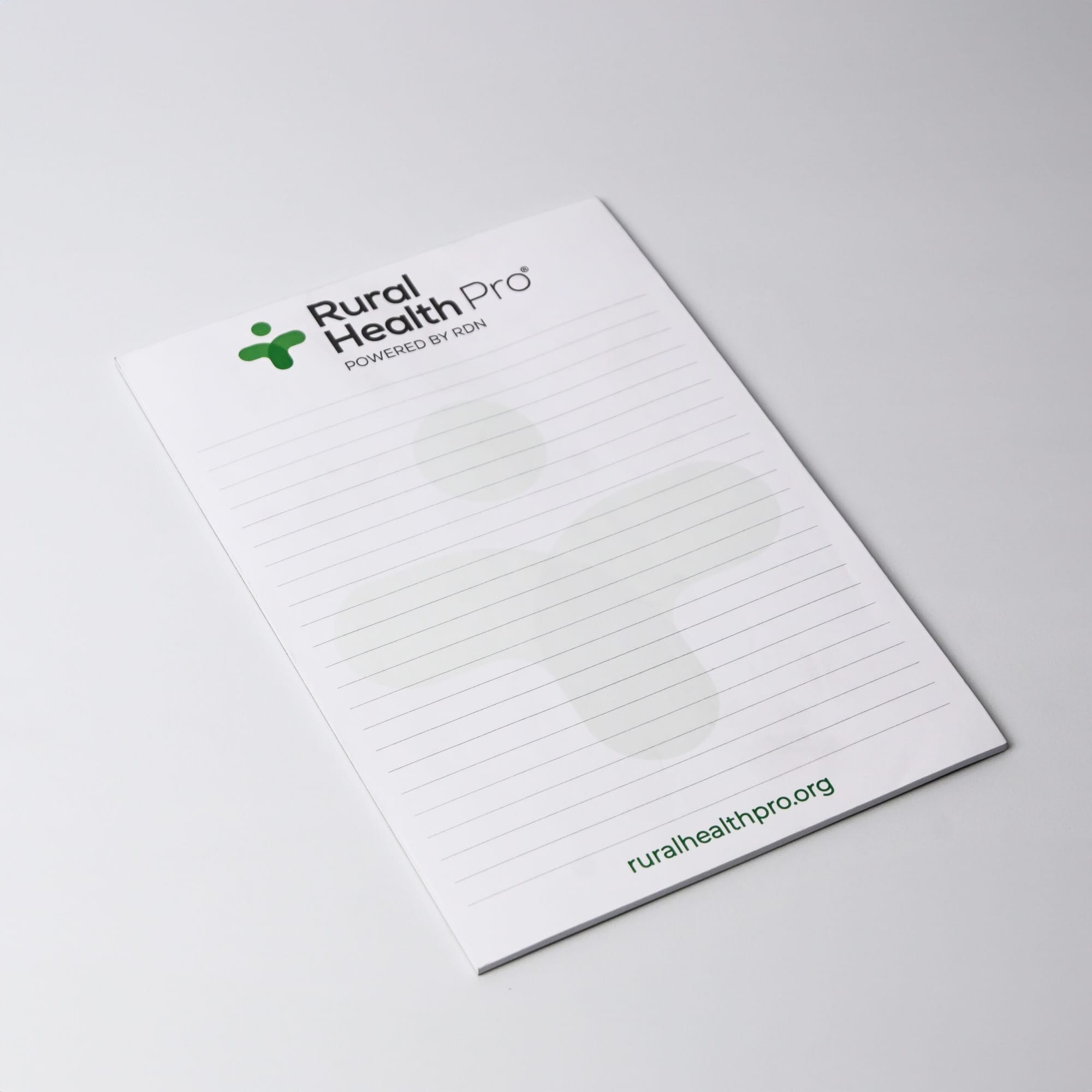 A5 notepad with 25 leaves, featuring a green logo, white background, and lined pages. Australian made.