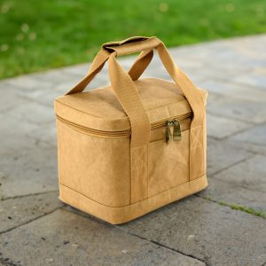 A tan kraft paper lunch cooler bag with a zippered closure and sturdy handles, placed on a stone surface.