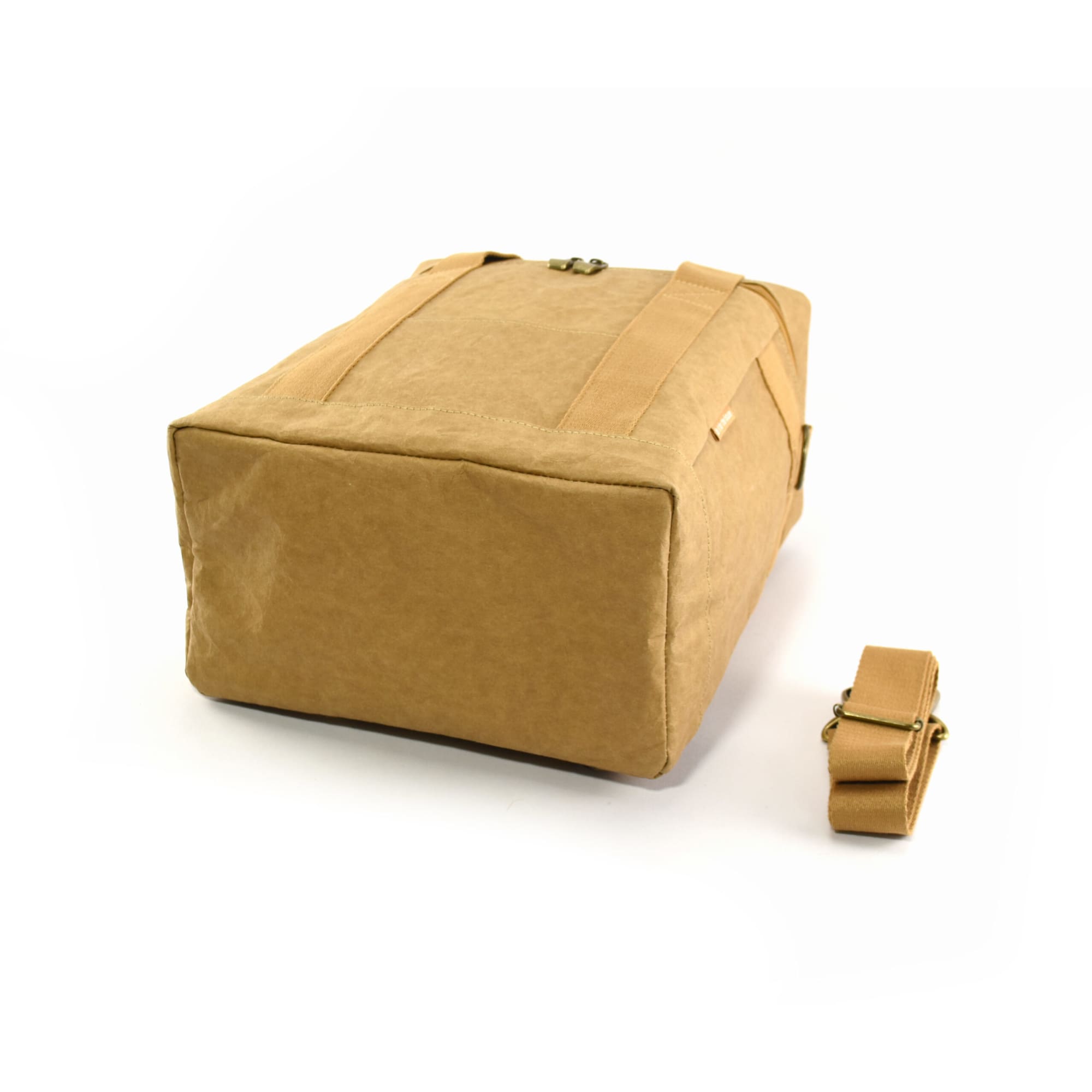 A tan cooler bag with sturdy straps and a detachable shoulder strap, featuring a simple design and a logo.