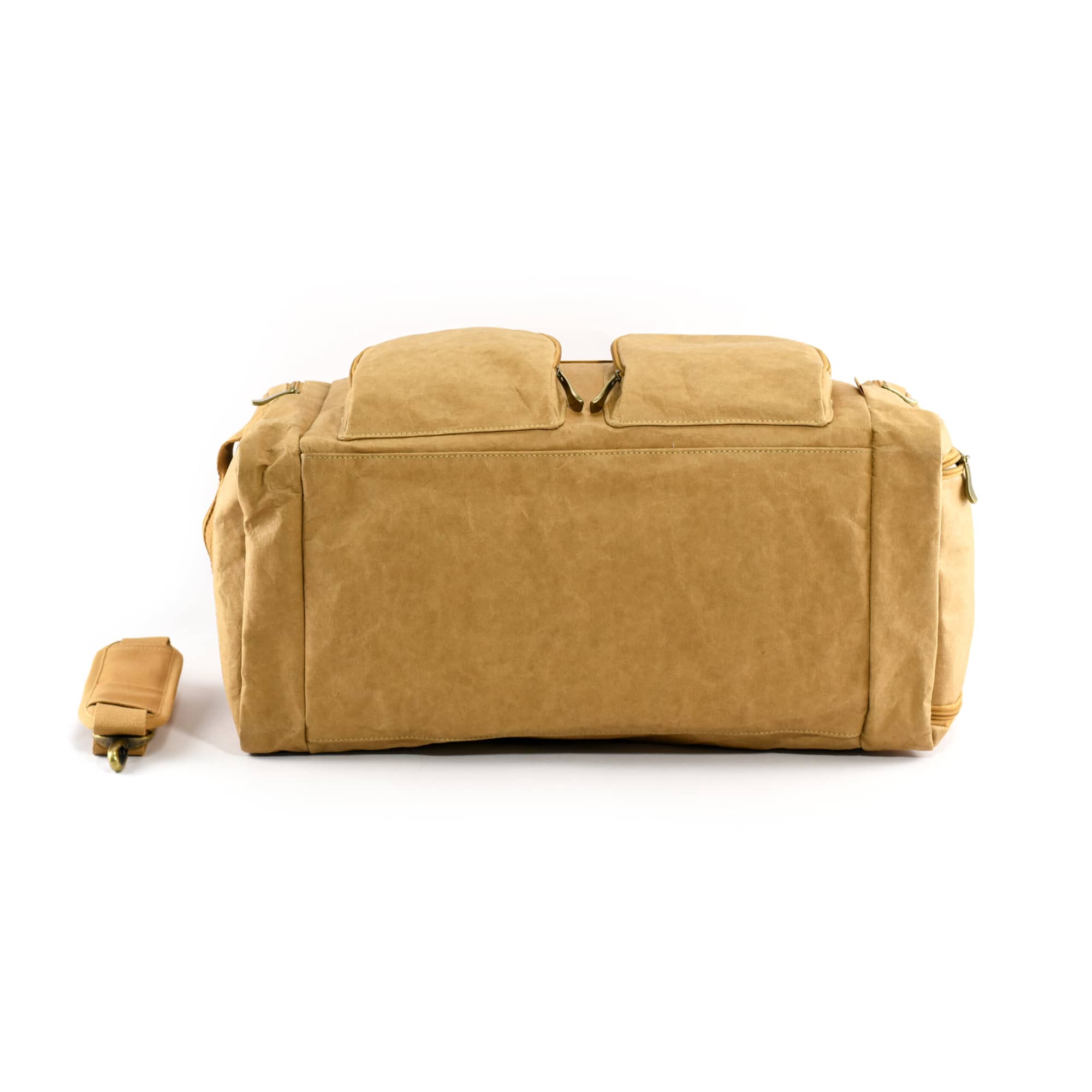 A tan kraft paper duffle bag with two front pockets and a detachable strap. It features a logo on the side.