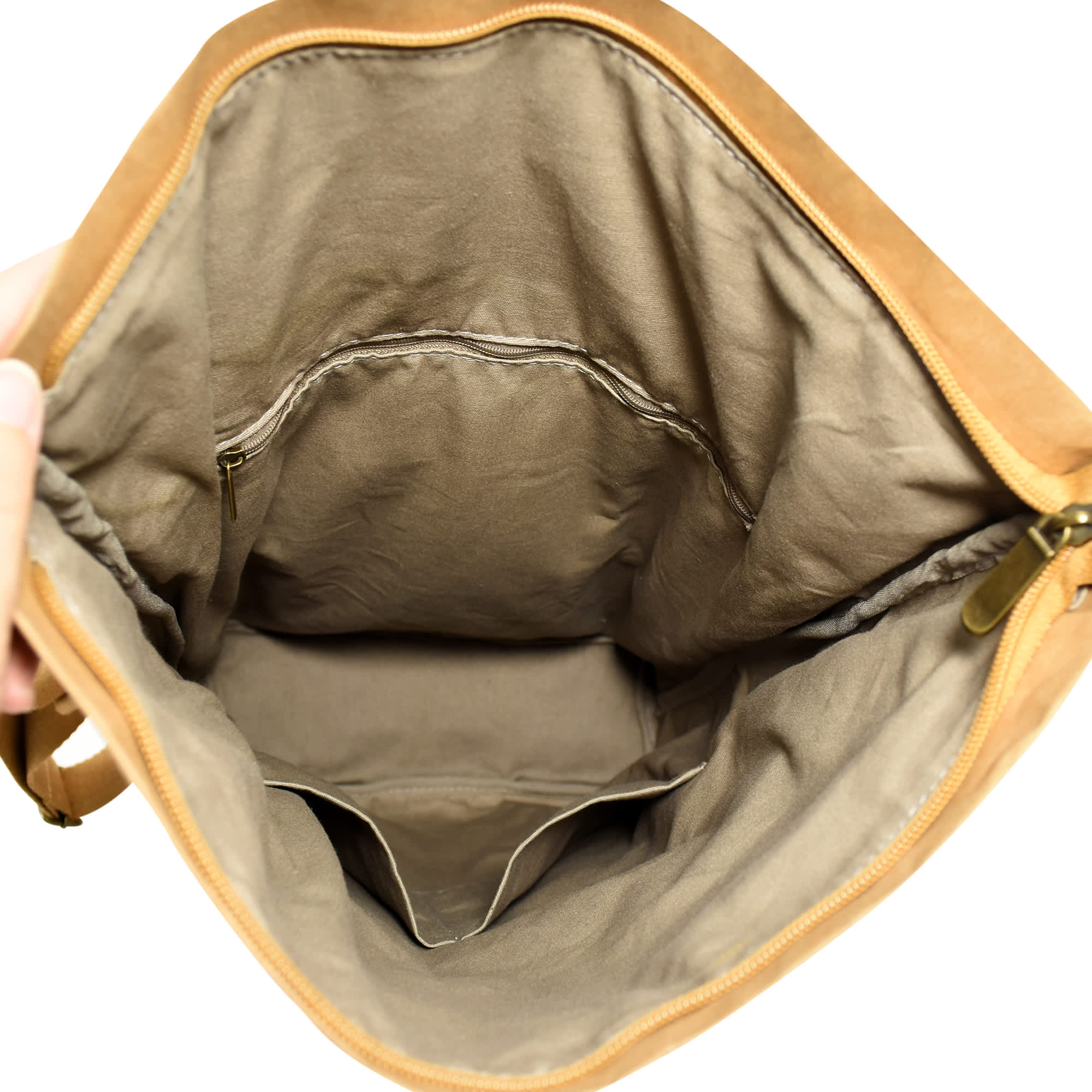 An interior view of a brown Kraft paper backpack, featuring a spacious compartment with a zipped pocket.