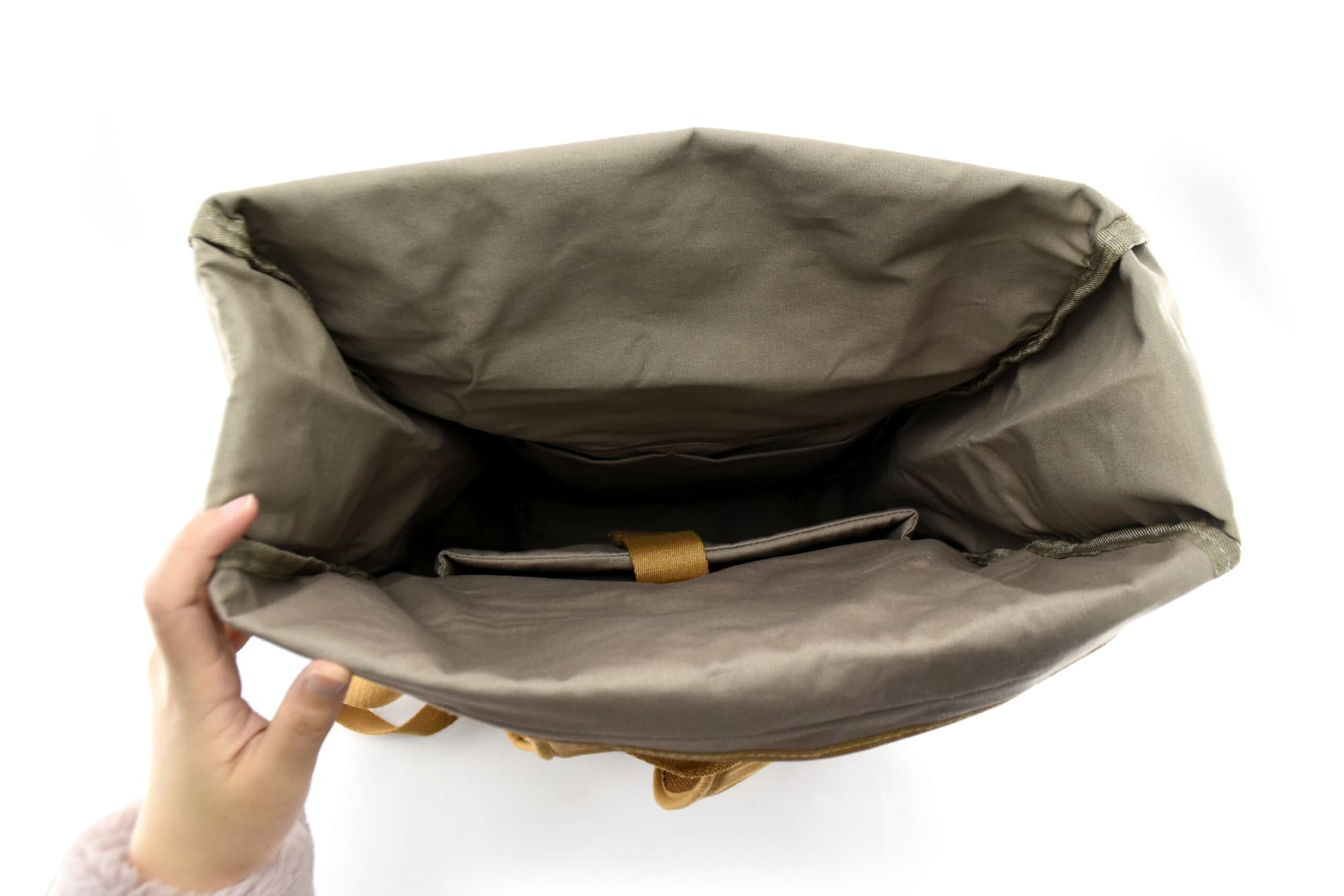 An open green leaf kraft paper laptop backpack revealing its spacious interior and a flat compartment for a laptop.