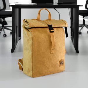 A tan kraft paper laptop backpack with a roll-top closure and a front buckle, featuring a logo.