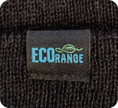 A close-up of a black fabric label featuring the words 