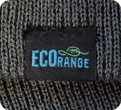 A textured grey beanie featuring a label with branding. The fabric appears to be knitted.