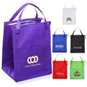 A purple insulated grocery tote with two handles, alongside various other coloured totes in black, red, white, and green.