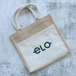 A jute tote bag in natural and cream colours with two handles and a logo on the front.