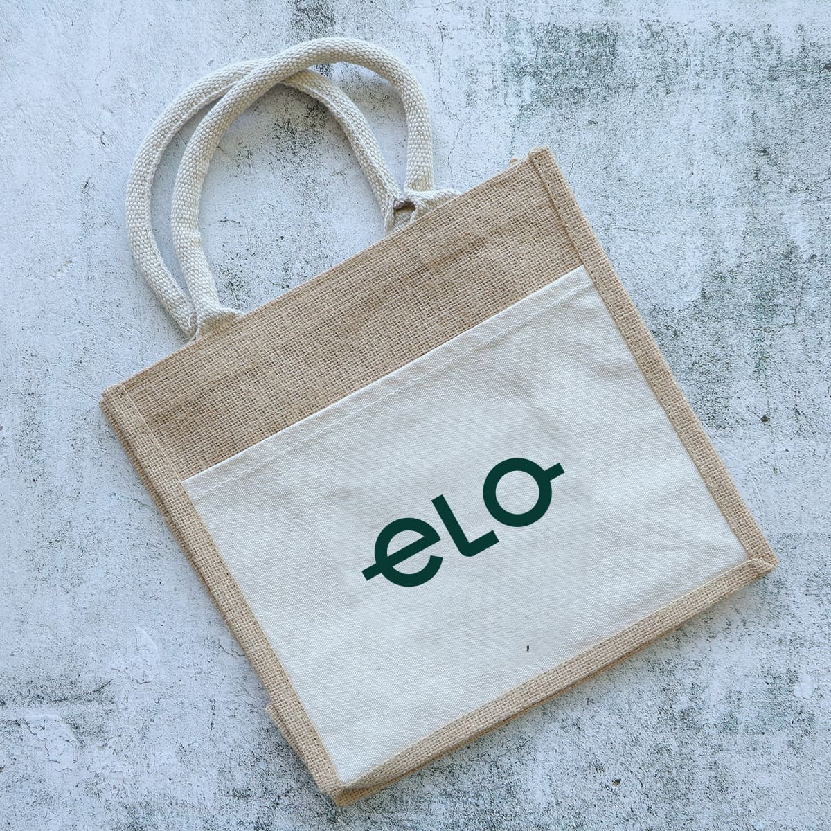 A jute tote bag in natural and cream colours with two handles and a logo on the front.