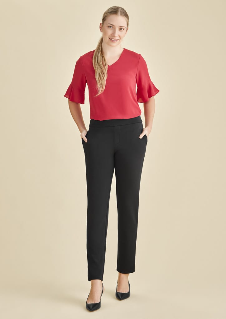 Mid-rise pull-on pants in black, styled with a red top, featuring a sleek design and pockets.