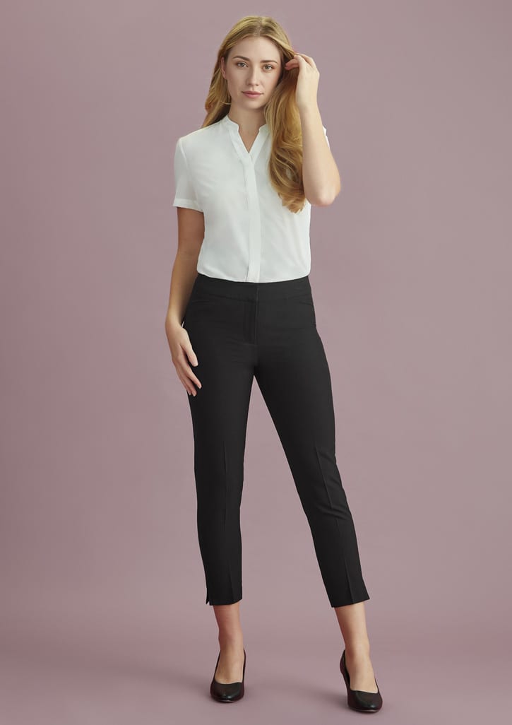 A pair of black mid-waist slim leg pants for women, styled with a white shirt and featuring a logo.
