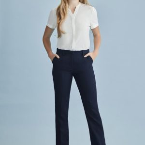 A woman models navy tapered leg pants with an adjustable waist, paired with a white blouse and heels, against a light blue background.
