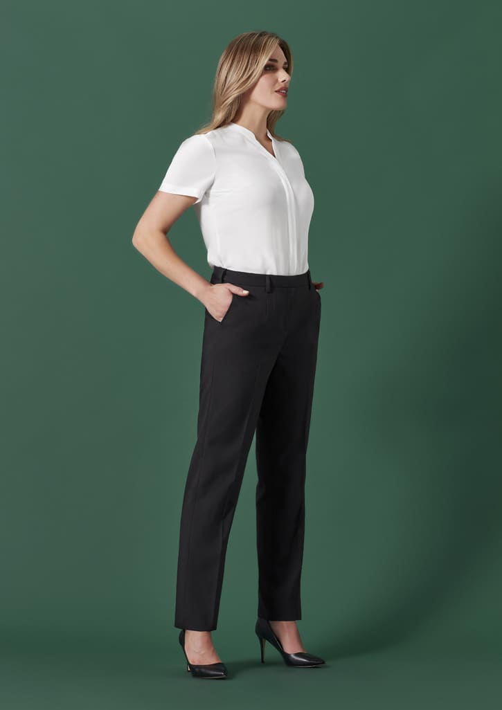 A pair of black tapered adjustable waist pants featured on a model against a green background, paired with a white top.