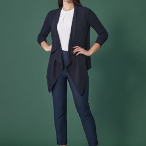 A model wearing navy mid-waist slim leg pants paired with a white top and a navy cardigan against a green background.