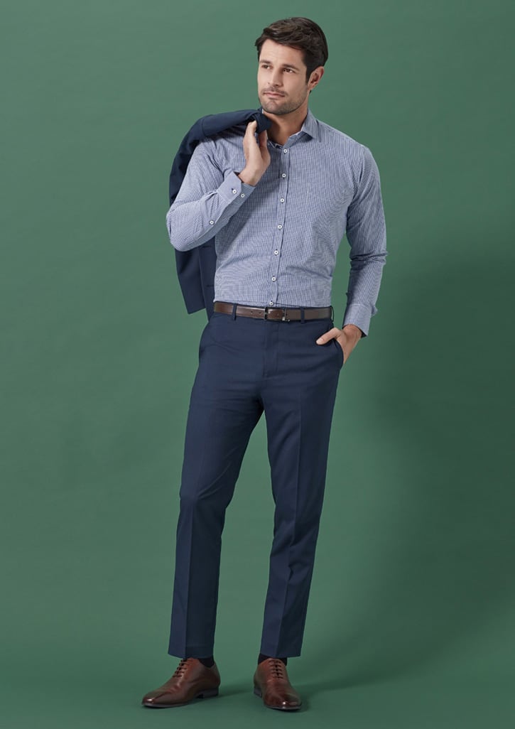 A pair of navy slim fit flat front pants displayed on a male model wearing a checked shirt and holding a blazer.