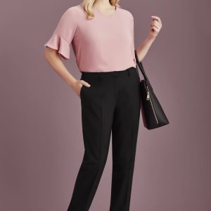 A pair of black slacks with a tailored fit, worn by a model with a pink top and holding a black handbag.