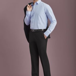 A man in a light blue shirt and black slacks, holding a black jacket on his shoulder. The slacks have a logo.