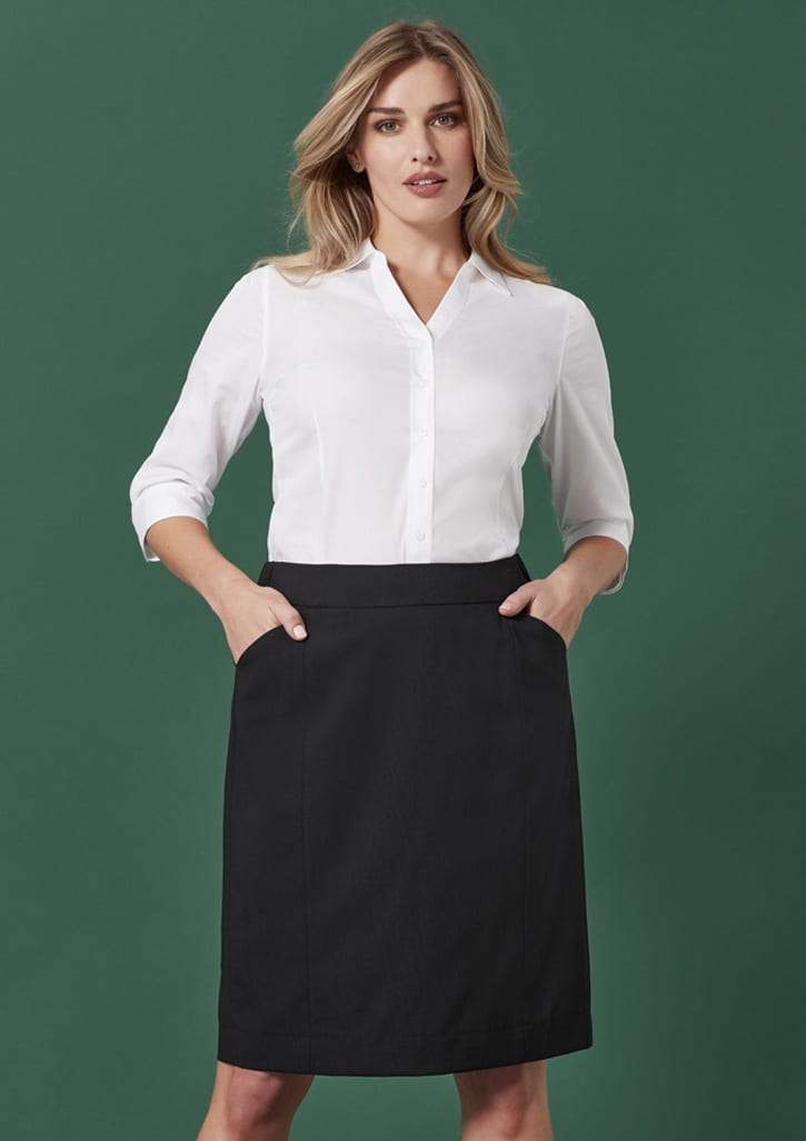 A pencil skirt in black, featuring a fitted design and pockets, paired with a white button-up shirt.