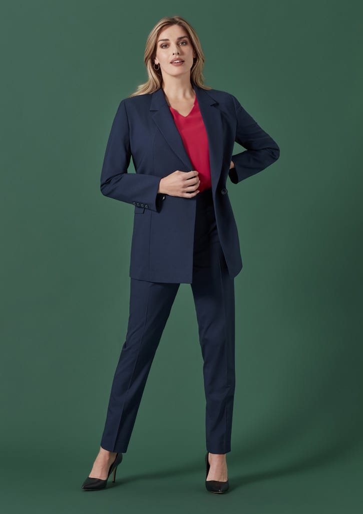 A navy double-breasted longline jacket is worn over a red top, paired with matching trousers and high heels.