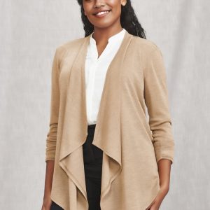 A woman wearing a beige waterfall cardigan over a white blouse and black trousers, smiling at the camera.