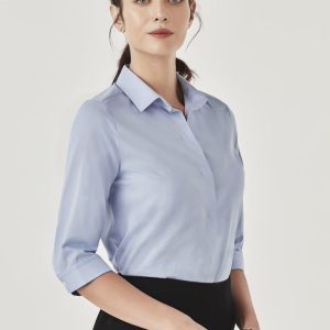 A light blue women's button-up shirt with three-quarter sleeves and a collar, featuring a subtle branding logo.