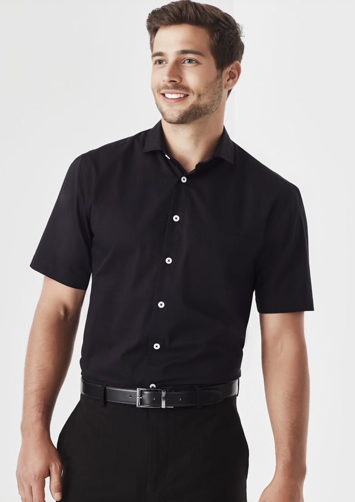 A black short sleeve button-up shirt with a classic fit, featuring a front pocket and a logo.