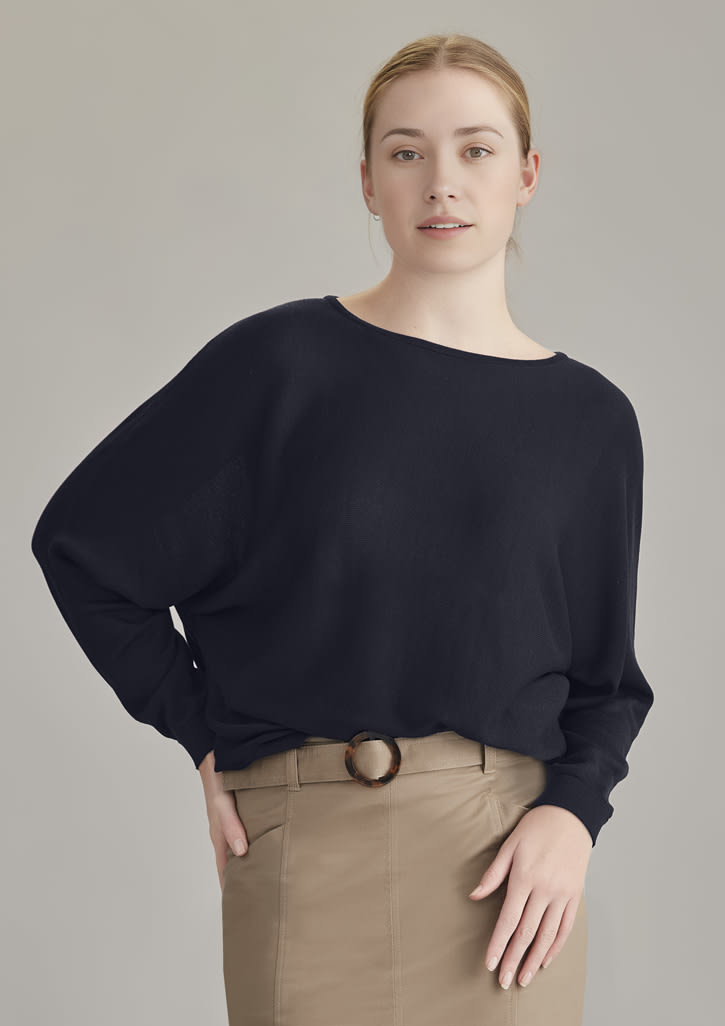 A black batwing sweater top worn by a model, paired with a beige skirt, showcasing relaxed fit and casual style.