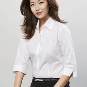 A model wears a white women's 3/4 sleeve button-up shirt, styled with black pants and a bracelet, featuring a logo.