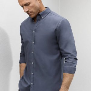 A grey long sleeve button-up shirt with a relaxed collar and a subtle logo.