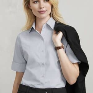 A light grey short sleeve button-up shirt featuring a classic collar, paired with black trousers. It has a logo branding.