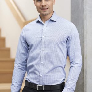 A tailored long sleeve shirt in light blue check pattern, featuring a logo, worn by a man against a staircase backdrop.