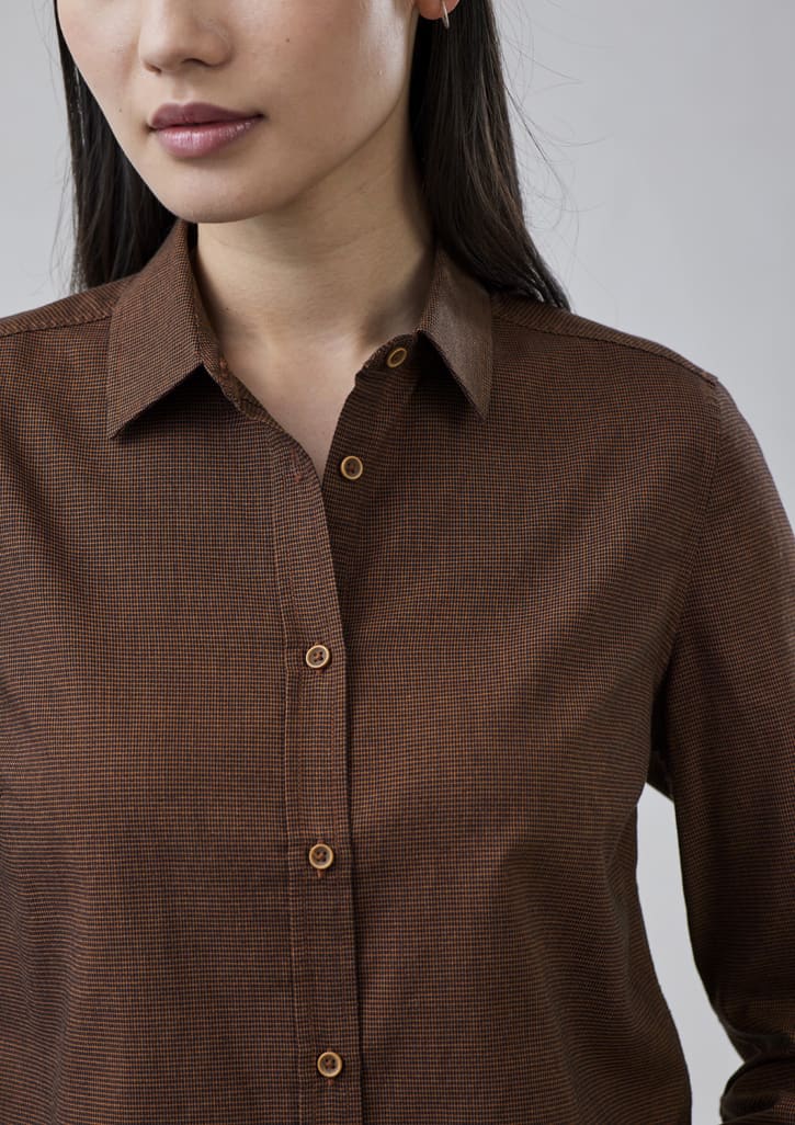 A brown button-up shirt featuring a subtle check pattern and a collared neckline, with buttons visible.