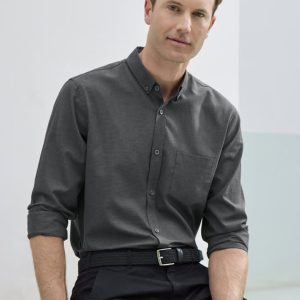 A long sleeve button-up shirt in charcoal grey, featuring a pocket and a branded logo, modelled by a man.